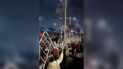 Workers throw parts of the metal barriers they demolished at the police.